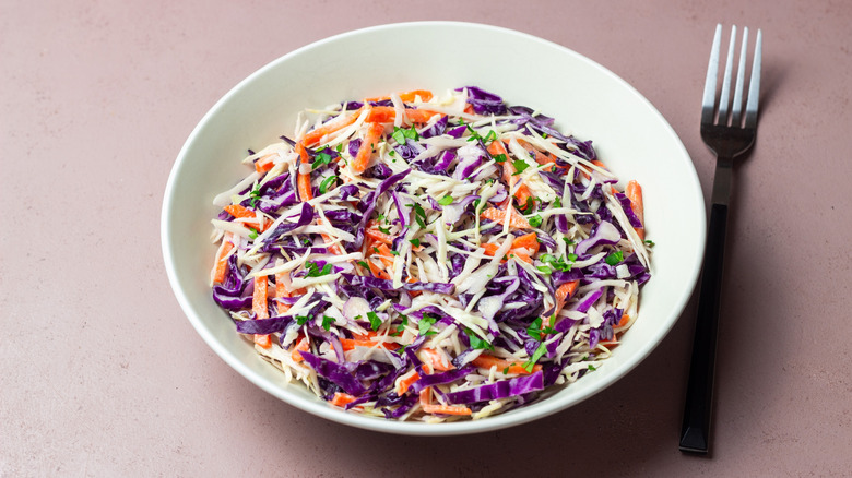A white bowl full of colorful coleslaw