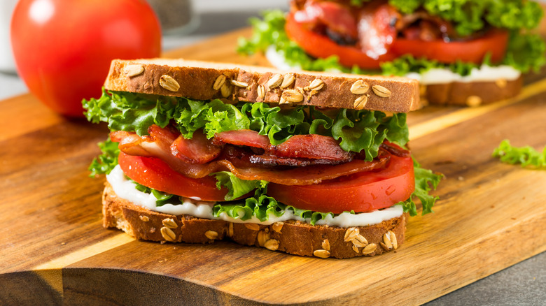 A BLT is arranged on a wooden board.