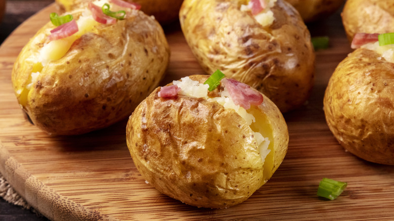Baked potatoes on wooden dish