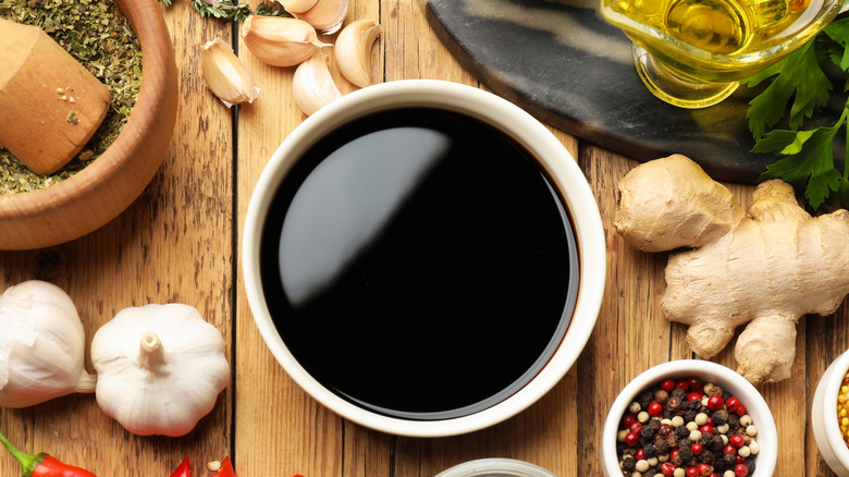 Bowl of soy sauce surrounded by seasonings