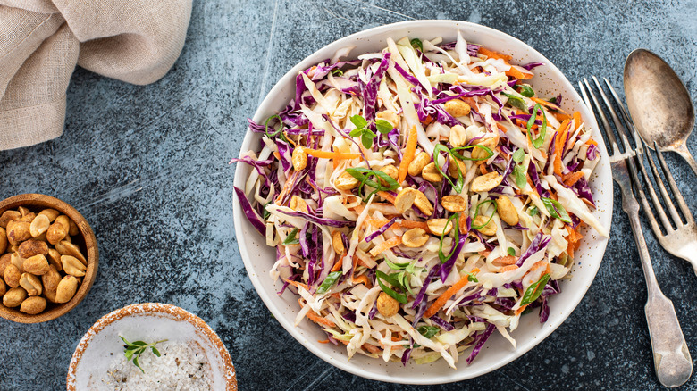 Asian cole slaw with peanut dressing, green onion and salted peanuts on top