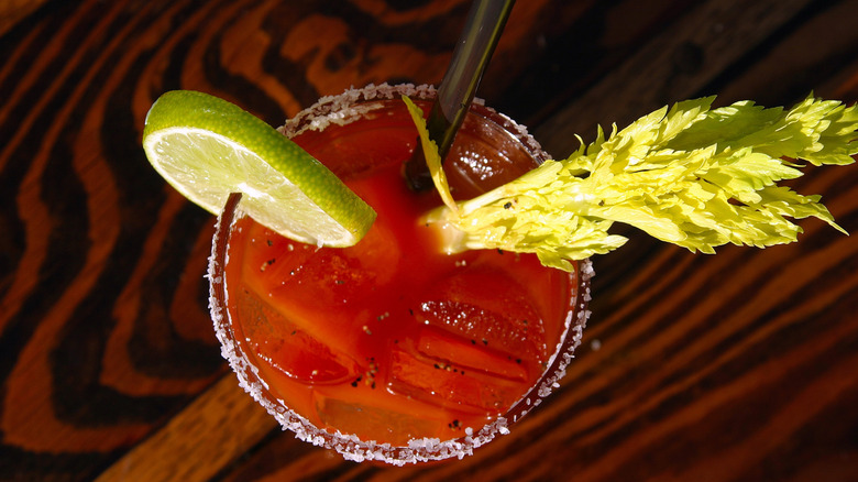 Top of a bloody Mary glass with celery and lime garnish