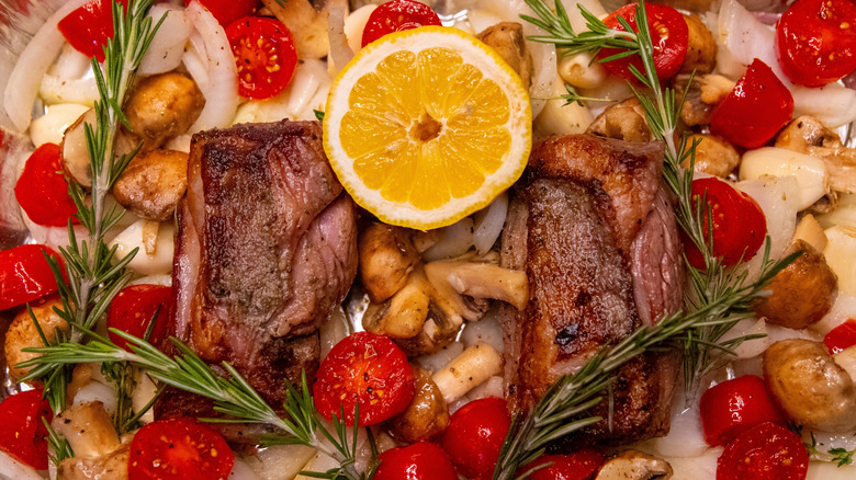 lamb pot roast with vegetables, a slice of lemon, and rosemary