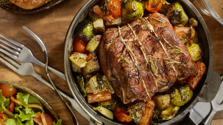 A pot roast dinner on a table with a side salad
