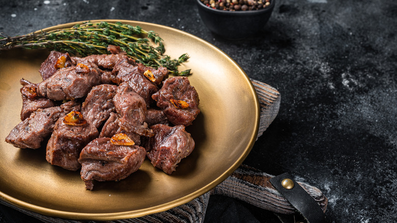 Beef tips on a plate with herbs