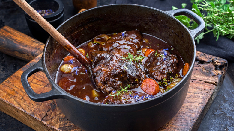 Pot roast in a Dutch oven on a cutting board.