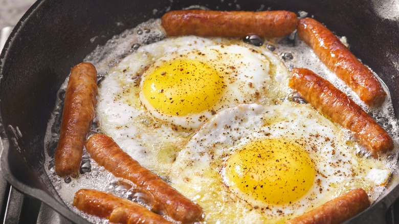 eggs and sausage cooking in skillet