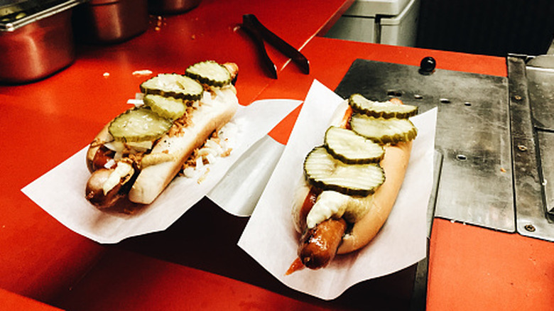 Two Danish hot dogs with slices of cucumber