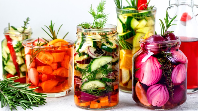 jars of pickled vegetables with an assortment of herbs and spices