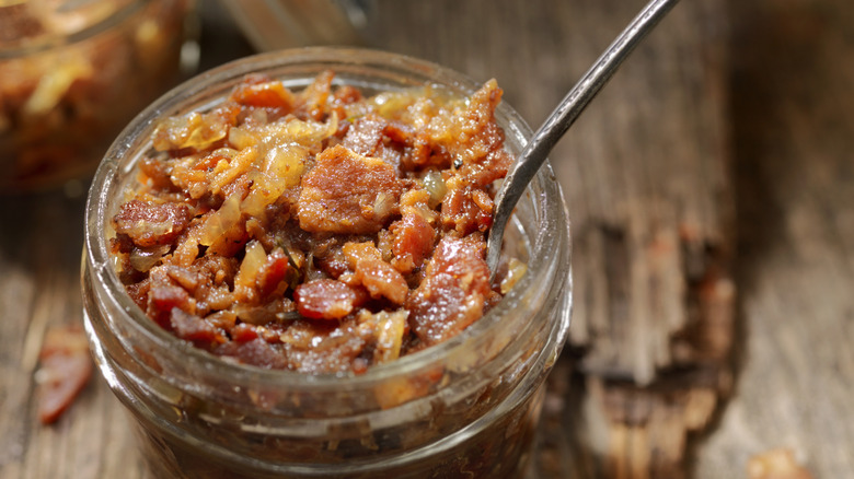 An open jar of bacon jam with a spoon in it