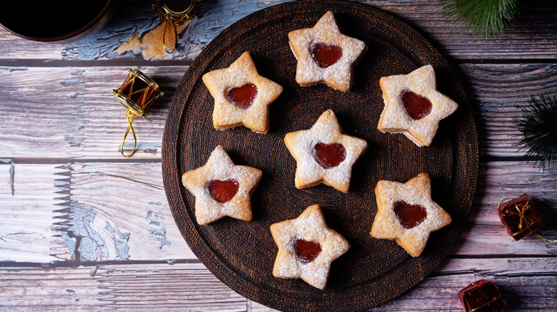Linzer shortbread cookies arranged on a table with holiday decor