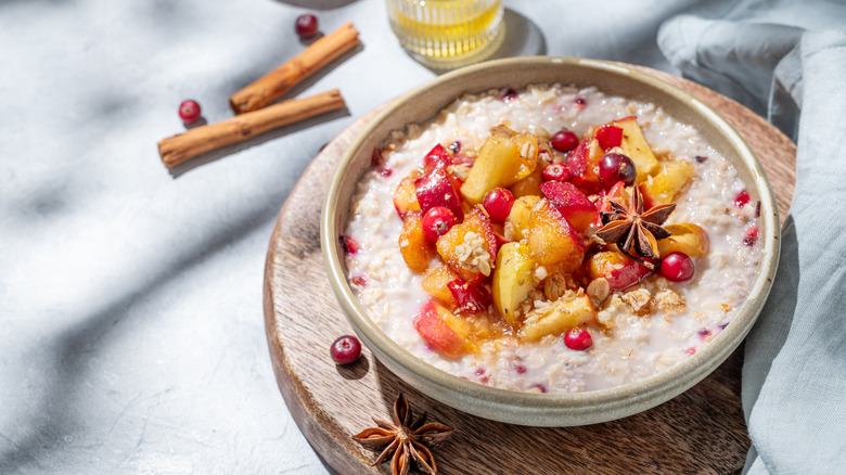 bowl of creamy oatmeal with fruits and spices on top
