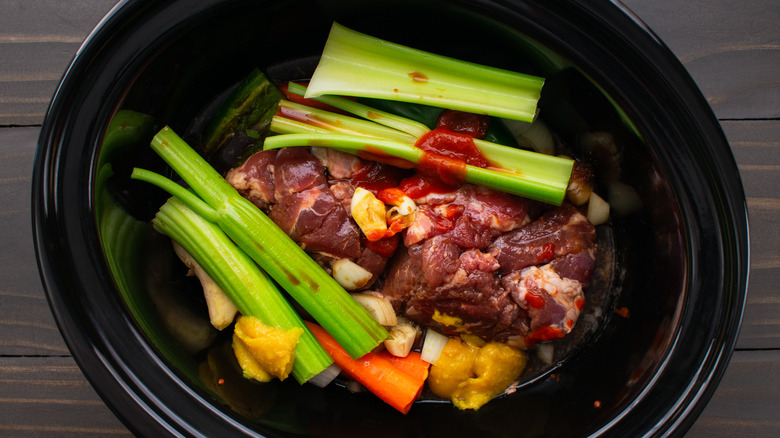 crockpot filled with pork and vegetables