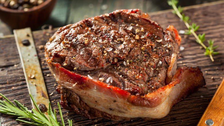 Bacon-wrapped filet mignon on a wooden board.