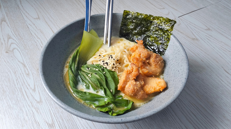 A bowl of ramen with karaage and seaweed