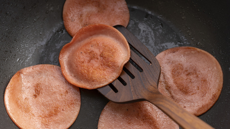 Spatula holding fried bologna
