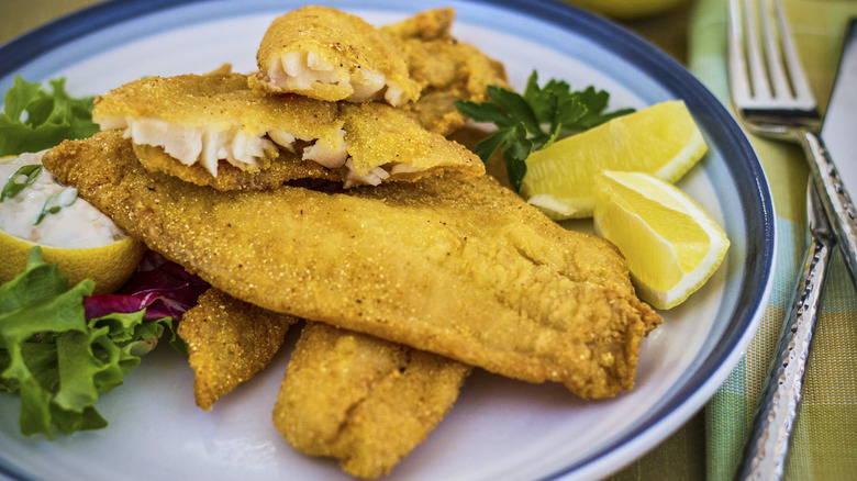 Crispy fried catfish with lemon wedges