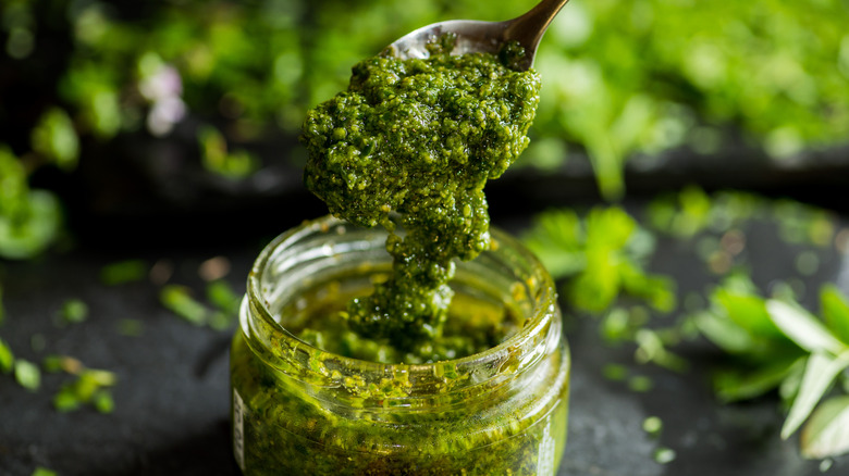 Pesto scooped in a spoon over a jar