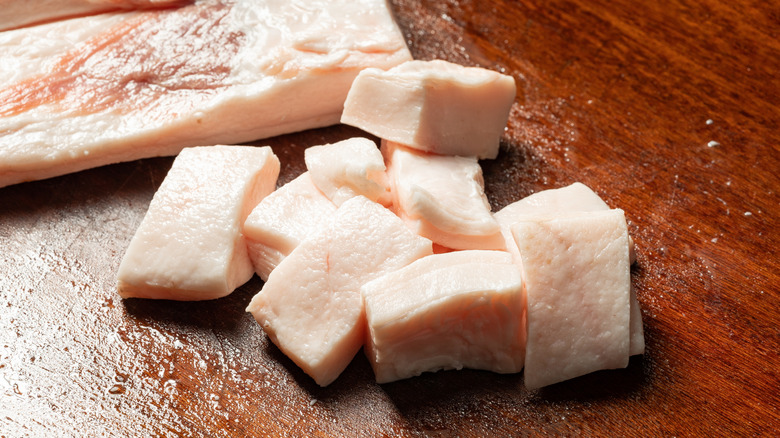 Cubes of beef suet on a chopping board.