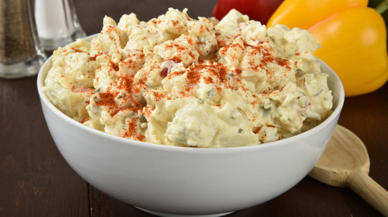 A white bowl full of creamy potato salad.