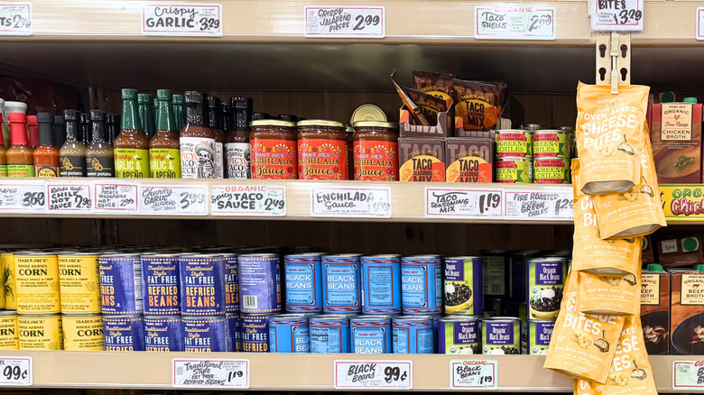 Trader Joe's shelves including hot sauces, taco mix, and canned beans