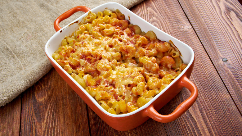 A baked pasta casserole in a red dish.