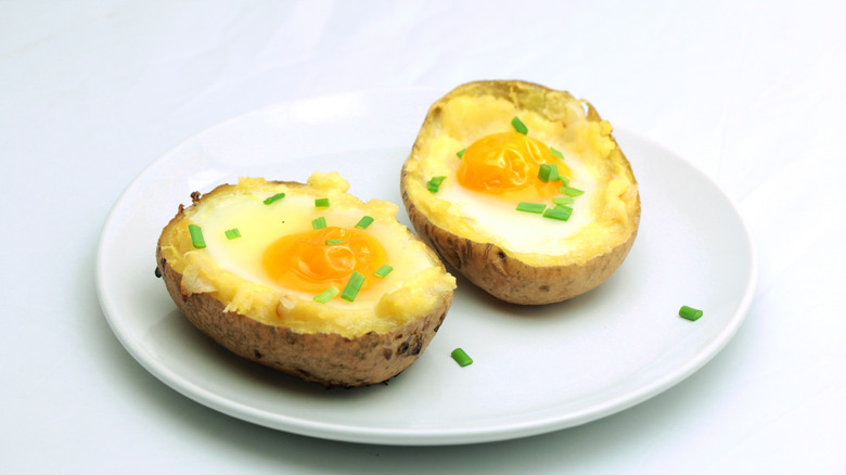Twice baked potatoes with egg on top laid over a white plate