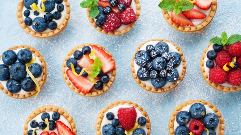 Fruit-topped mini pies on a blue table