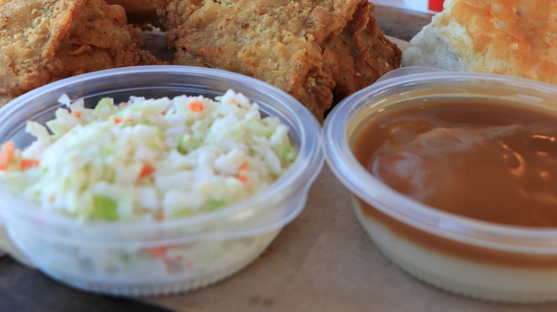 Close-up of KFC gravy, slaw, chicken, and a biscuit