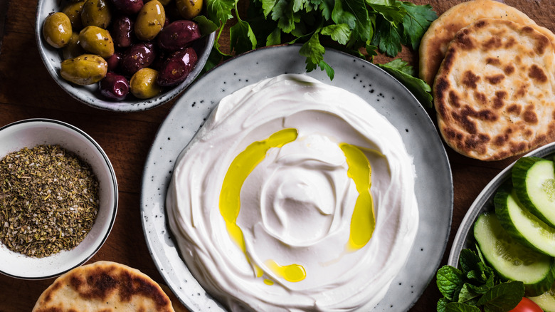 labneh dip in a bowl with sliced veggies