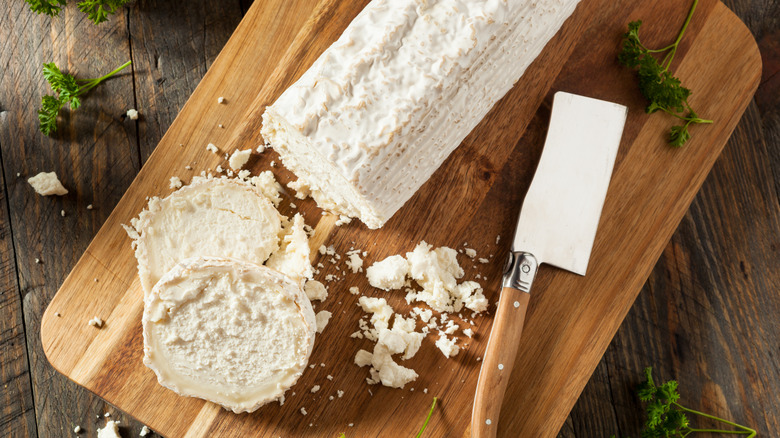 goat cheese sliced on a wooden cutting board