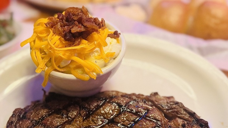 Loaded mashed potatoes and a steak on a plate