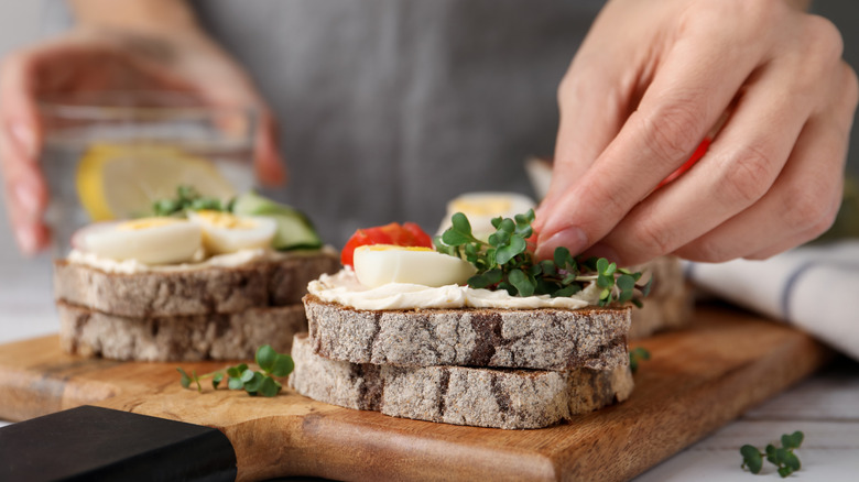 Hands making a breakfast sandwich
