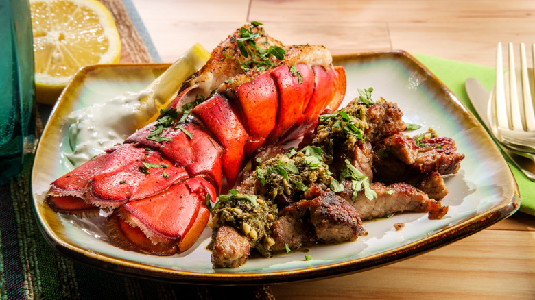 Lobster tail and steak on a plate