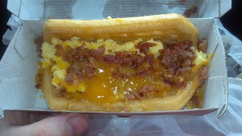 A close up of someone's hand holding a Taco Bell Waffle Taco