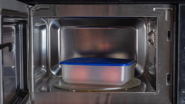 A plastic container in an open microwave.
