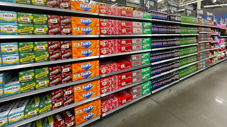 A stocked grocery store soda aisle.
