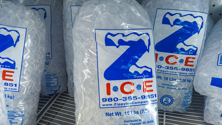 Bags of ice stacked in a commercial freezer.