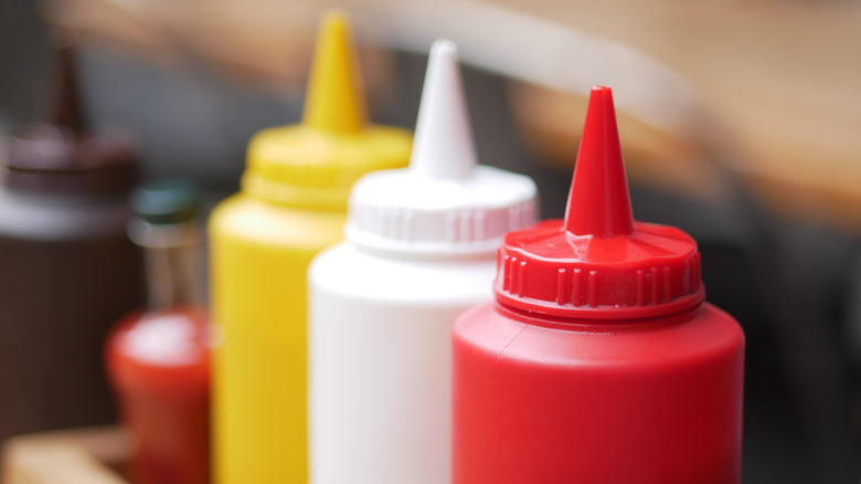 Squeeze bottles of ketchup, mayo, and mustard.