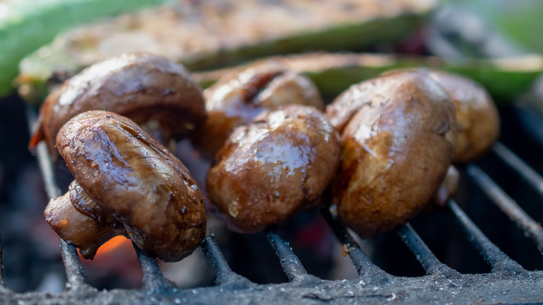 Mushrooms cooking on a grill.