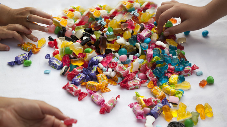 Hands sorting through pile of candy on table