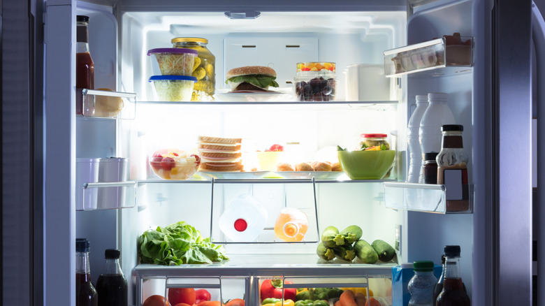 Open fridge with various food items on shelves