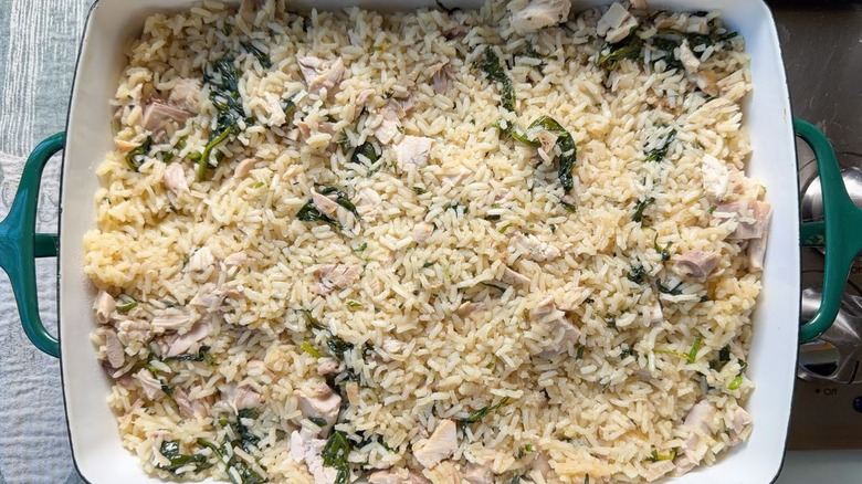 Cooked rice, chicken and spinach in baking dish