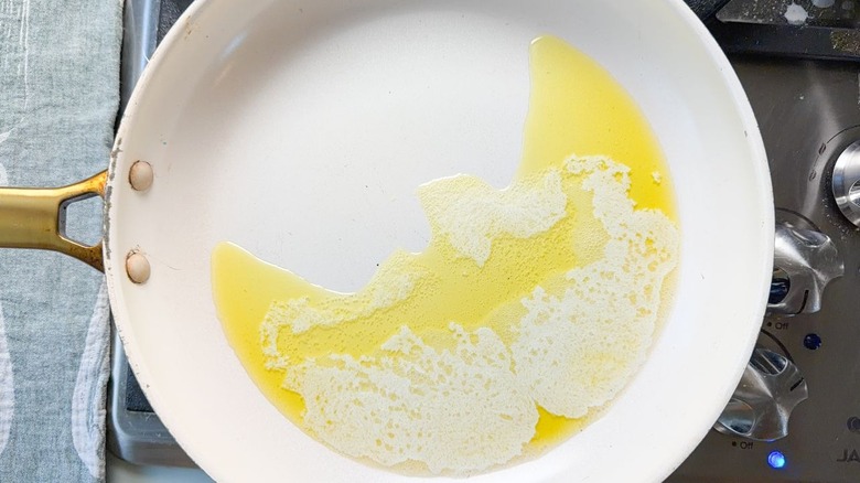 Butter and olive oil heating in a large white skillet