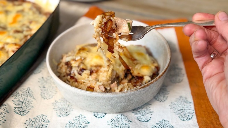 Forkful and bowl filled with French onion chicken and rice casserole