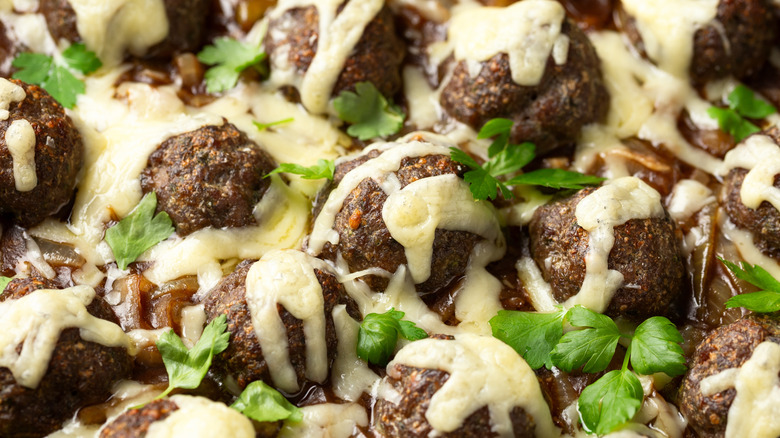 Meatballs topped with melted cheese and parsley