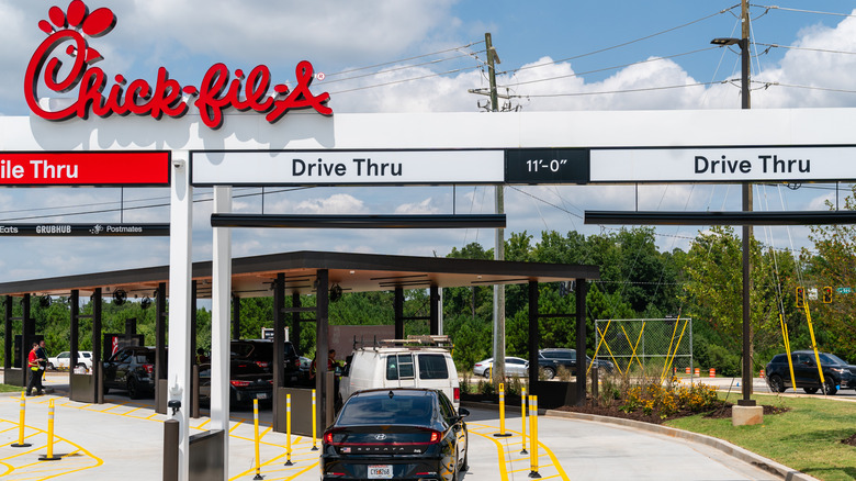 multiple drive-thru lanes at a Chick-fil-A with an employee taking orders in background