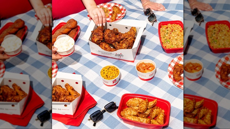 a spread of food from Bonchon Korean, including chicken, potstickers, corn, kimchi and others