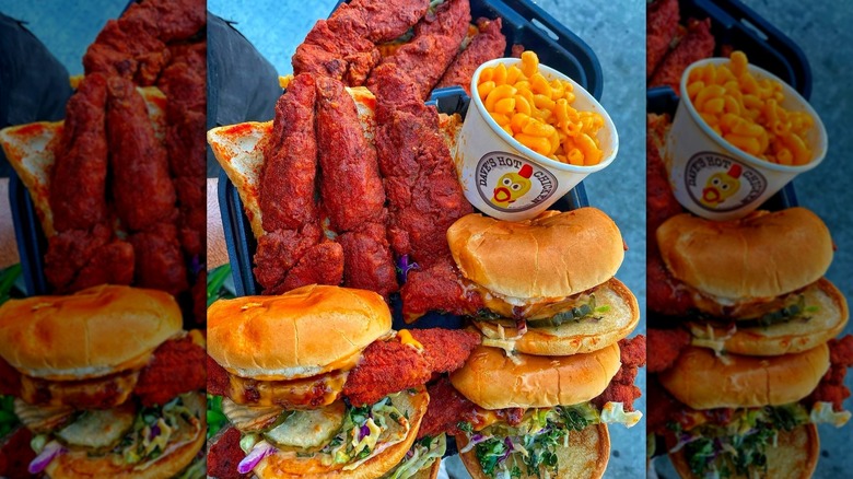 a large platter of Dave's Hot Chicken pieces with three sandwiches and a cup of mac and cheese