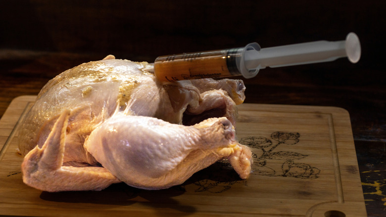 An individual injecting a chicken.